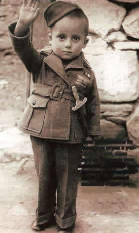 Дети не виноваты во взрослых играх и участвуют в них, сами того не понимая: этот мальчик в полном солдатском обмундировании и с деревянной шпажкой отдает фашистский салют. Август 1938 год